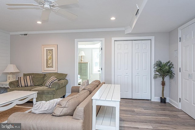 living room with hardwood / wood-style flooring, ornamental molding, and ceiling fan