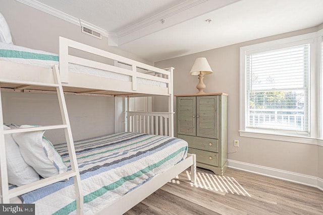 bedroom with hardwood / wood-style floors and crown molding