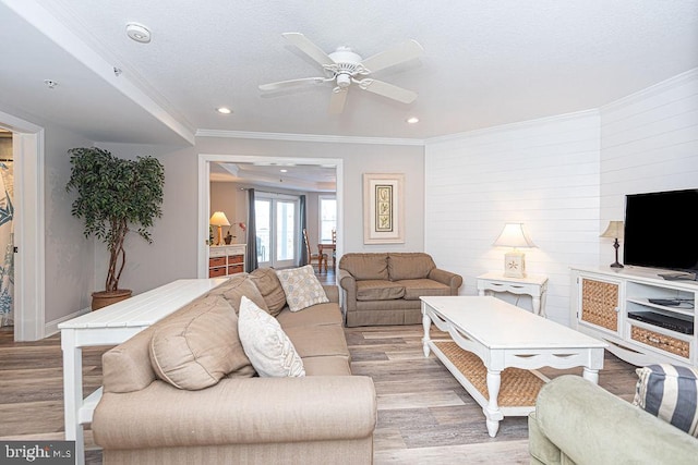 living room with crown molding and light wood-type flooring