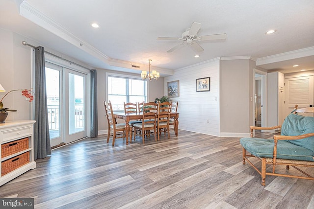 dining space featuring ornamental molding, ceiling fan with notable chandelier, and light hardwood / wood-style flooring