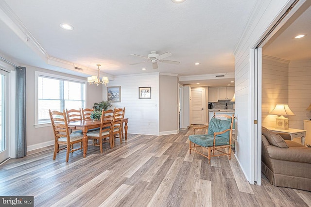 dining room with crown molding, ceiling fan with notable chandelier, and light hardwood / wood-style floors