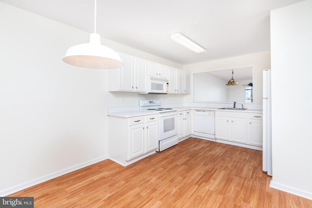 kitchen featuring pendant lighting, white appliances, white cabinetry, and sink