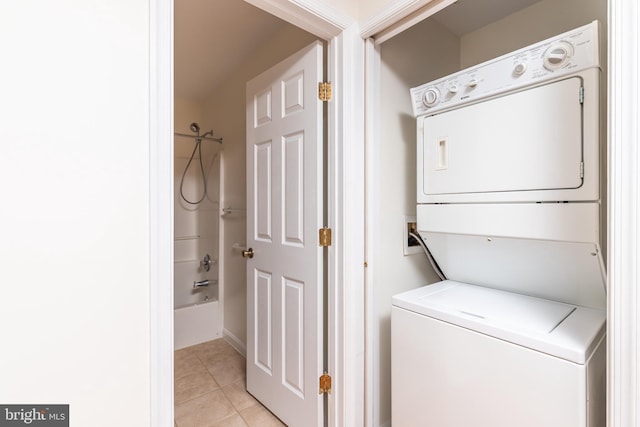 laundry area with light tile patterned flooring and stacked washer / drying machine