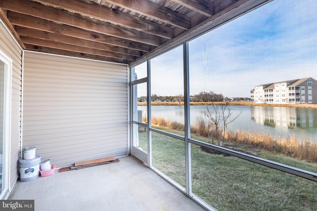 unfurnished sunroom with a water view