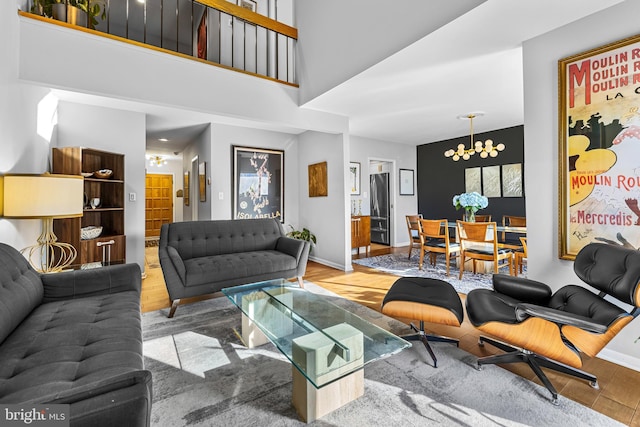 living room with hardwood / wood-style flooring, a high ceiling, and a notable chandelier