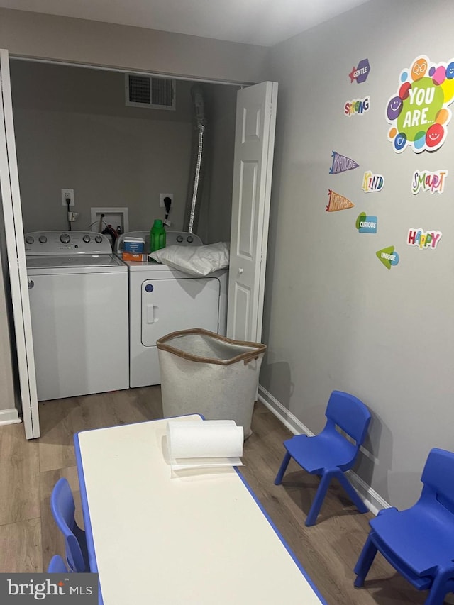 laundry area with hardwood / wood-style flooring and separate washer and dryer