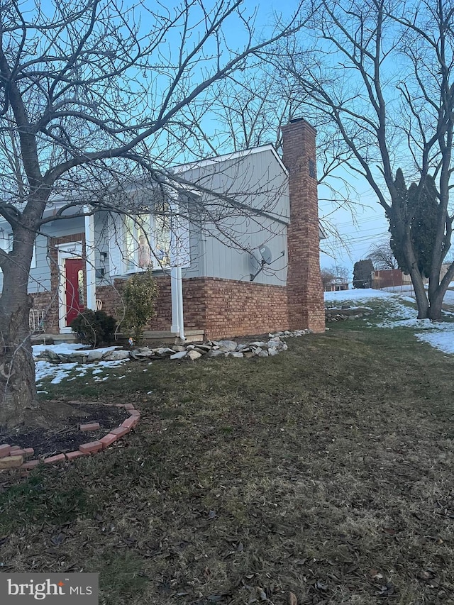 view of side of home with a yard