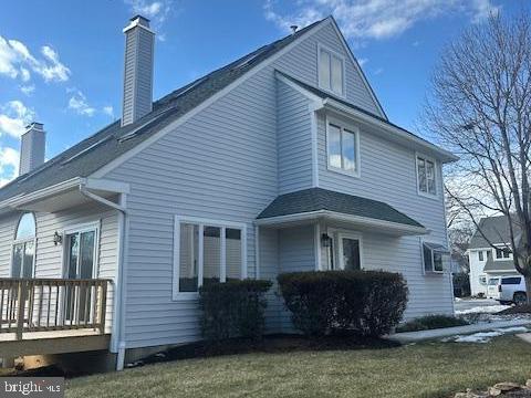 view of side of home featuring a lawn and a deck