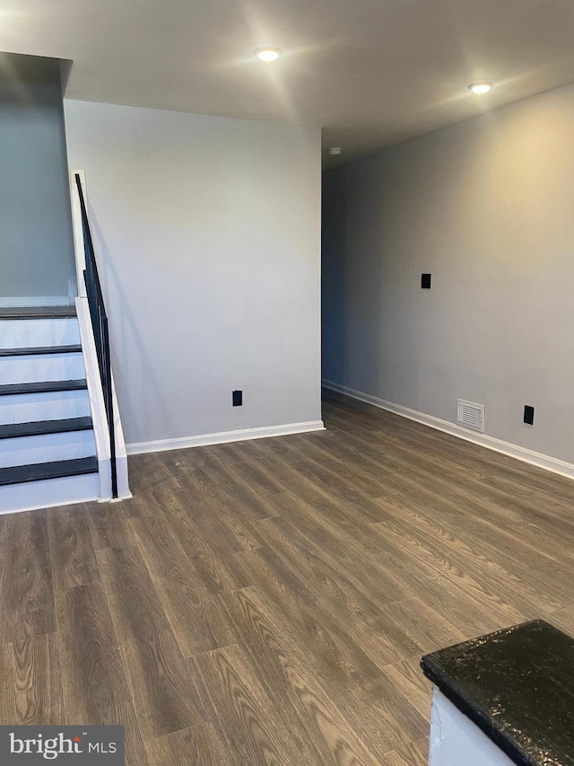 interior space featuring stairs, dark wood finished floors, visible vents, and baseboards