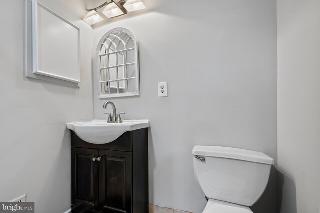 half bathroom with toilet and vanity