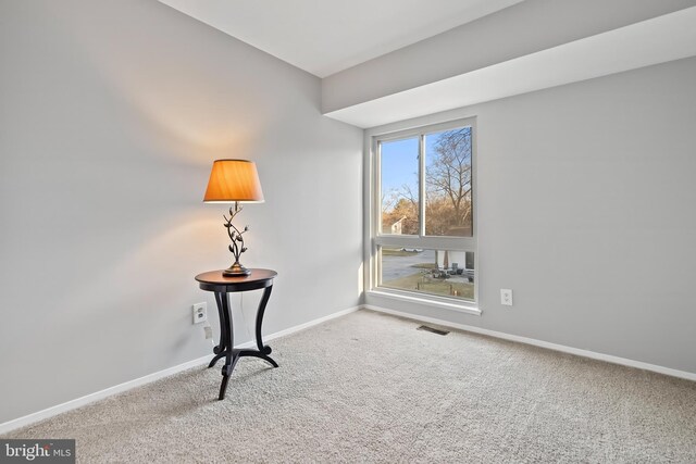 unfurnished room with baseboards, carpet floors, and visible vents