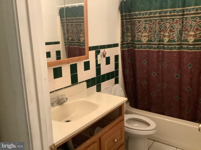 full bathroom featuring tile walls, vanity, toilet, shower / bathtub combination with curtain, and tile patterned floors