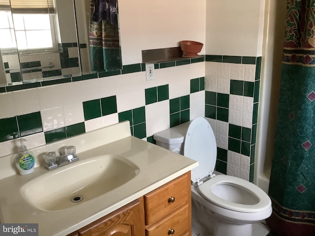 bathroom featuring vanity, toilet, and tile walls