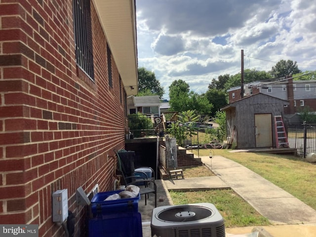 view of side of home with central air condition unit and a shed