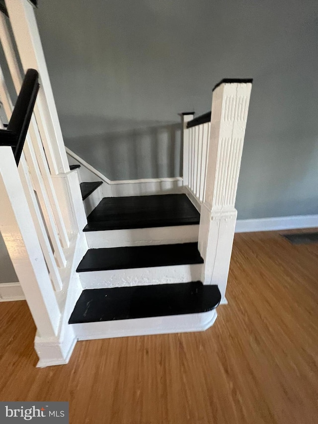 stairs with hardwood / wood-style flooring