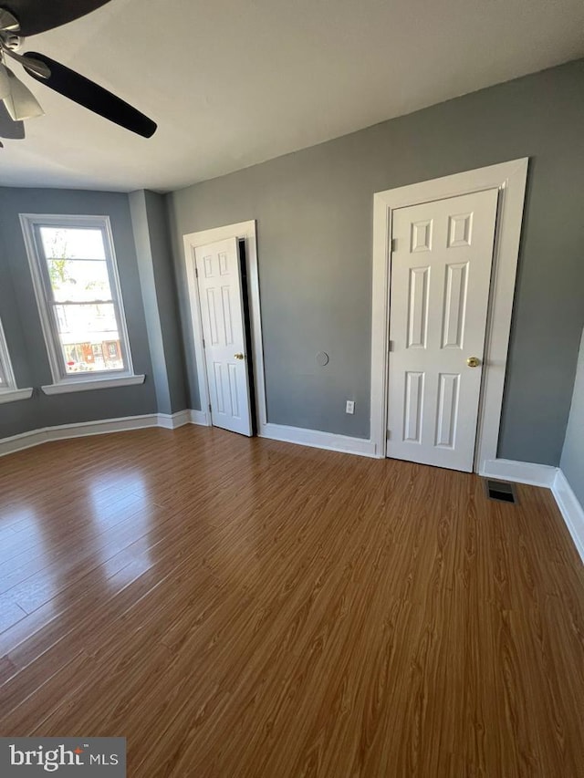 unfurnished bedroom with ceiling fan and hardwood / wood-style floors