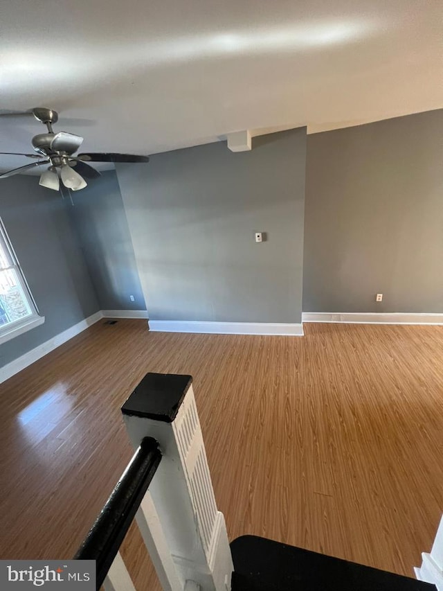 empty room with hardwood / wood-style flooring and ceiling fan