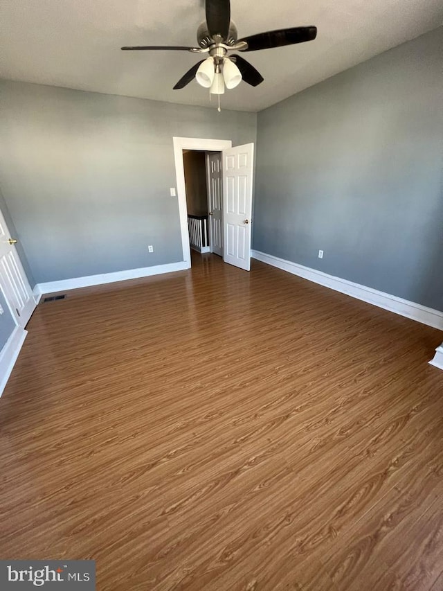 interior space featuring dark wood-type flooring and ceiling fan