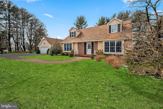 cape cod-style house featuring a front yard and a garage