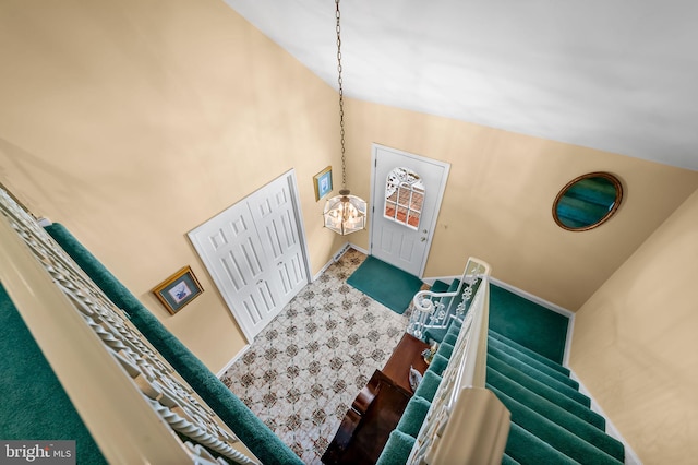 carpeted foyer entrance with a high ceiling