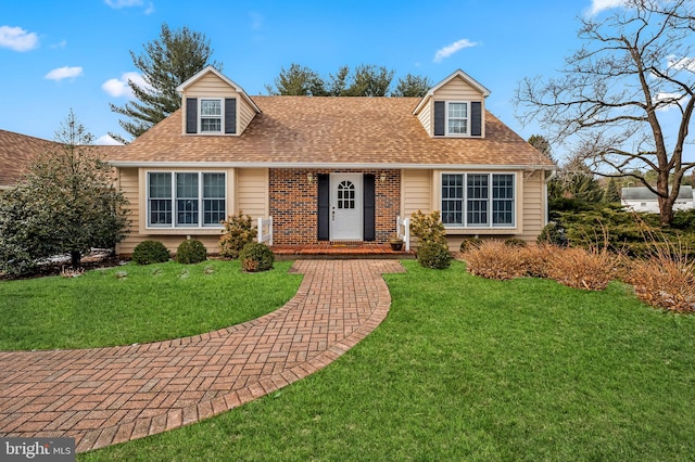 cape cod home featuring a front lawn