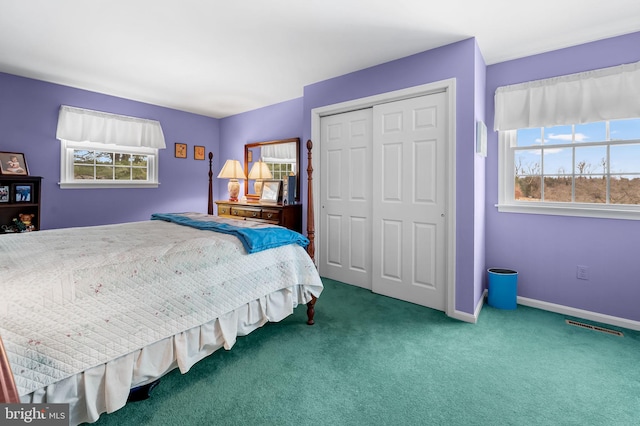 bedroom with multiple windows, a closet, and carpet floors