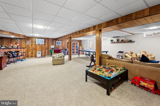 recreation room with carpet, wooden walls, and a paneled ceiling