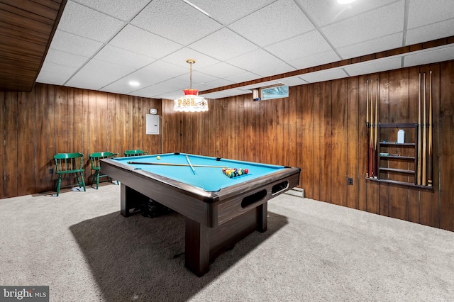 game room with a drop ceiling, pool table, wood walls, and light colored carpet