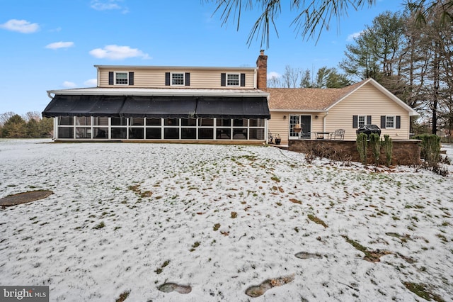 snow covered house with a sunroom