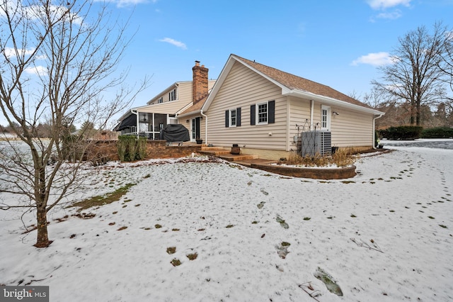 view of snowy exterior featuring a sunroom