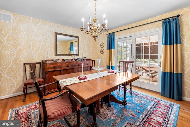 dining space featuring a chandelier, french doors, and wood-type flooring