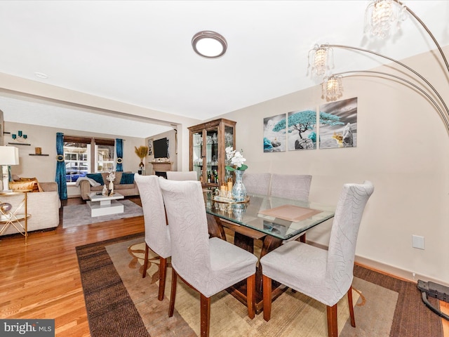 dining area featuring hardwood / wood-style floors and an inviting chandelier