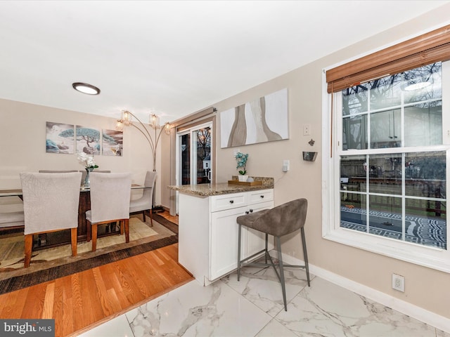 kitchen with white cabinetry and dark stone countertops