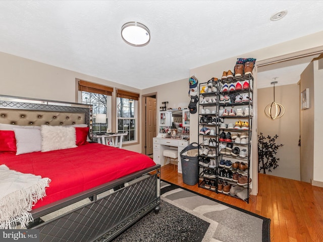 bedroom with hardwood / wood-style floors and a textured ceiling