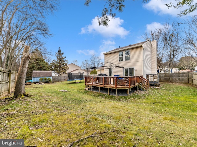 back of property with a deck, a storage unit, a trampoline, a yard, and a gazebo