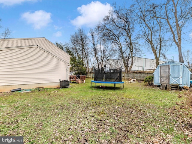 view of yard with a trampoline, central AC unit, and a shed