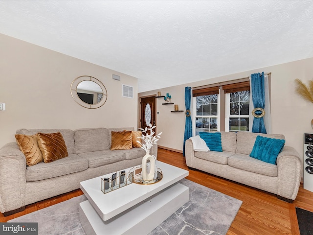 living room with hardwood / wood-style floors and a textured ceiling