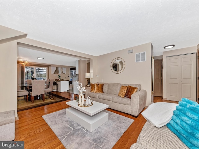 living room with light hardwood / wood-style floors and a textured ceiling