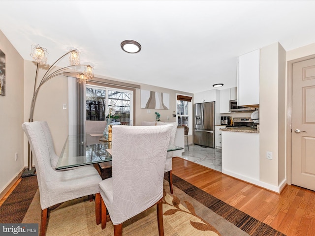 dining space featuring light hardwood / wood-style floors and a notable chandelier