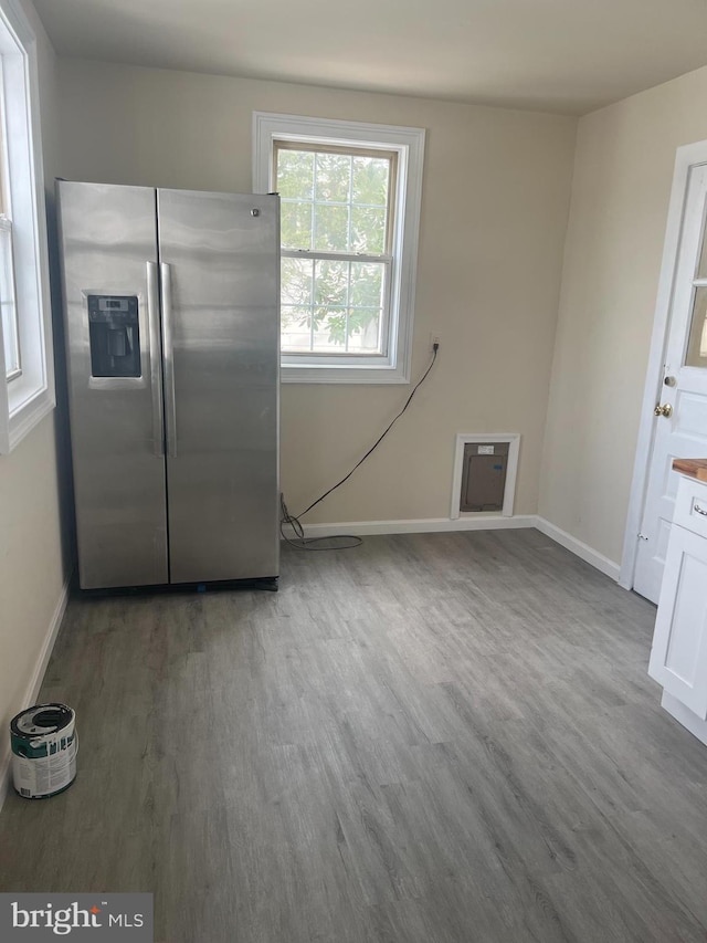 kitchen with white cabinetry, hardwood / wood-style floors, and stainless steel fridge