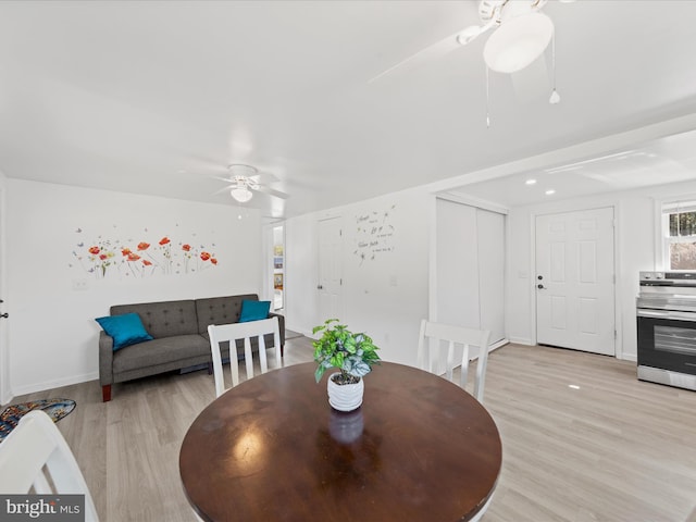 dining area with light wood-style floors, ceiling fan, and baseboards