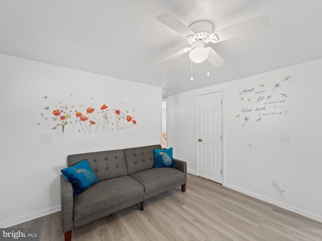 living room featuring a ceiling fan, light wood-style flooring, and baseboards