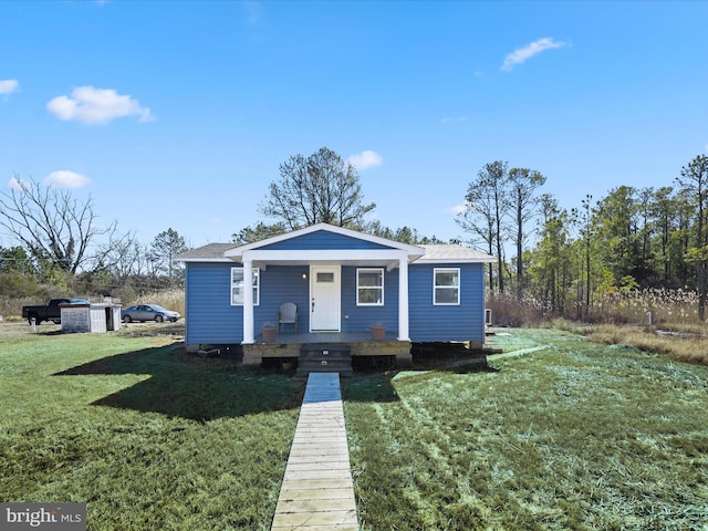 bungalow-style home featuring covered porch and a front lawn