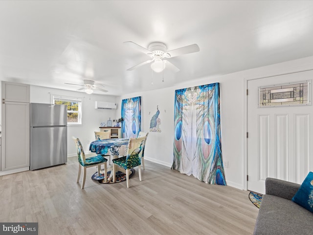 dining area with a wall unit AC, light wood-style floors, ceiling fan, and baseboards