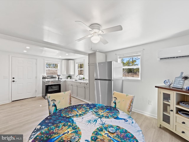 dining area with light wood-style floors, baseboards, a ceiling fan, and a wall mounted AC