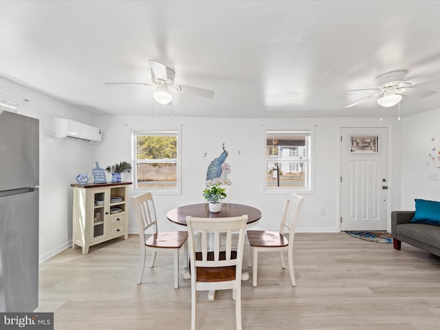 dining room with ceiling fan, light wood-type flooring, a wall unit AC, and baseboards