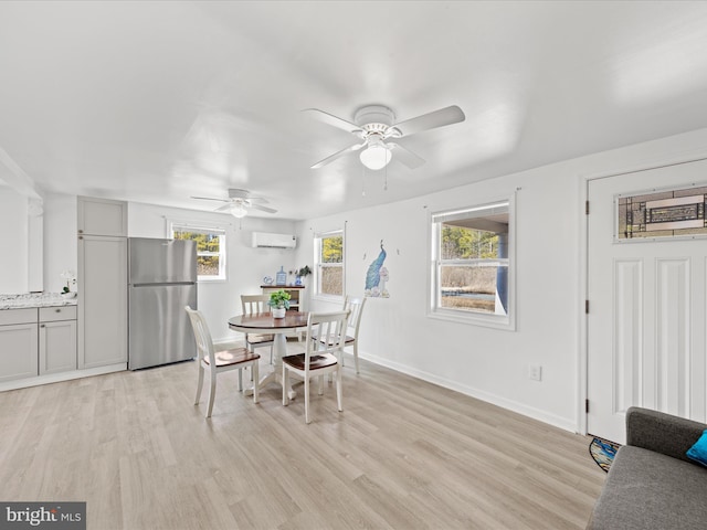 dining space featuring baseboards, ceiling fan, a wall mounted air conditioner, and light wood-style floors