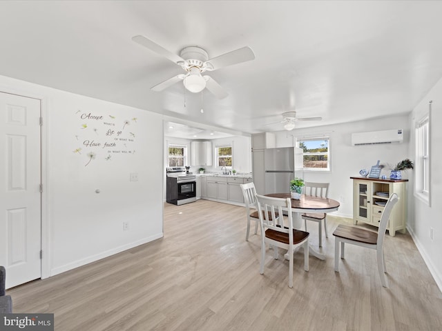 dining space featuring light wood finished floors, a wall unit AC, a ceiling fan, and baseboards