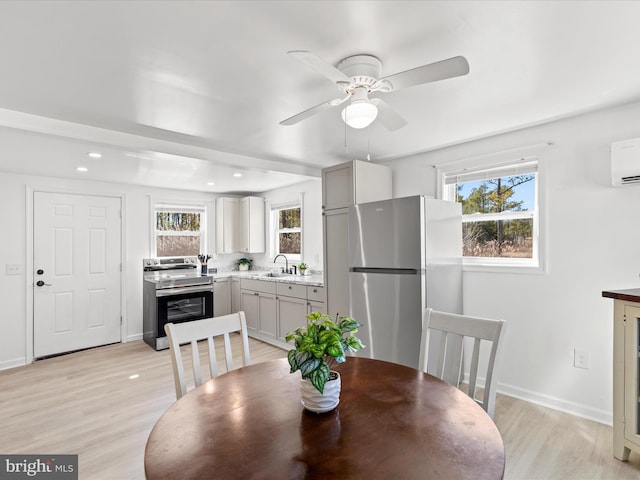 dining area featuring light wood-style floors, plenty of natural light, and baseboards