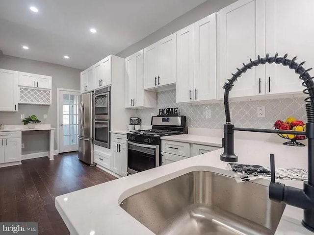 kitchen featuring backsplash, appliances with stainless steel finishes, and white cabinets